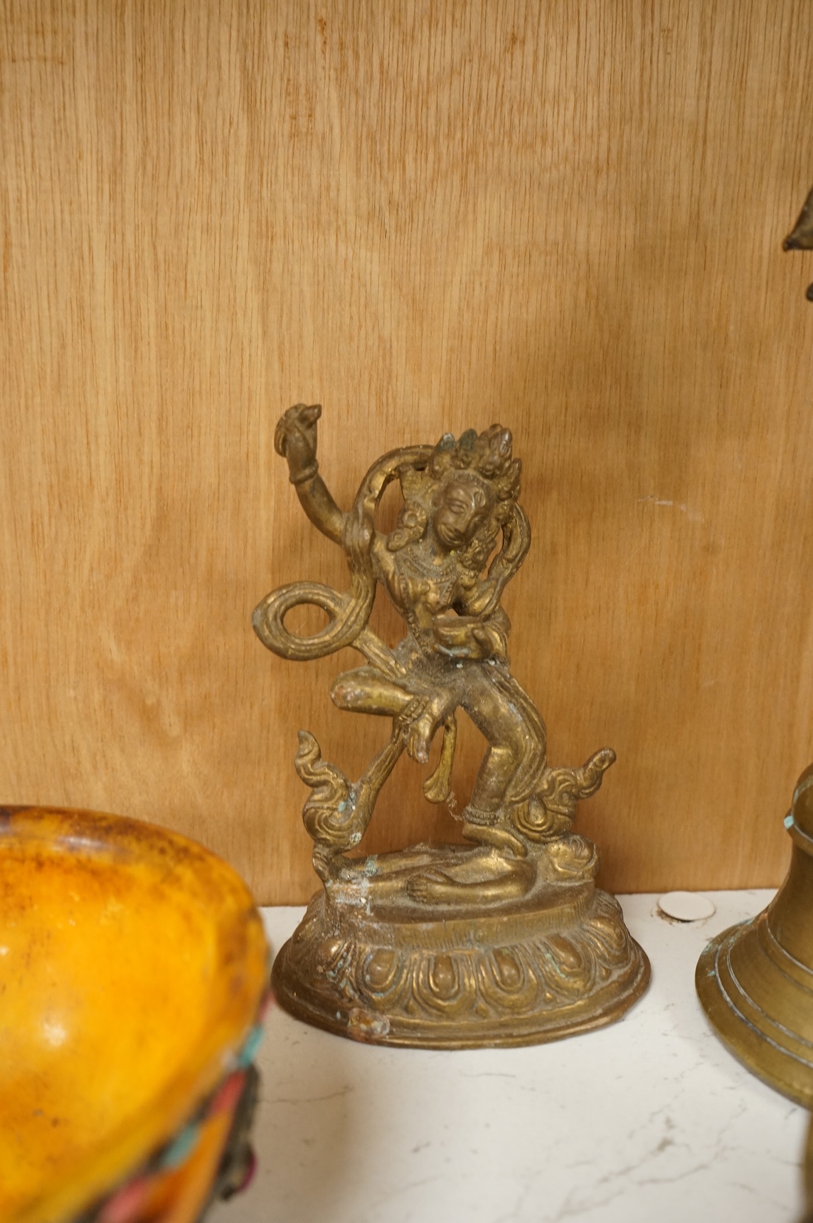 A group of Tibetan brass and mixed metal artefacts to include a brass vase with cabochon inset stones and figures of deities, largest 22cm high